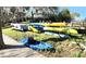 Scenic waterfront property featuring stacked colorful kayaks stored near a wooden dock at 20800 River Dr # A17, Dunnellon, FL 34431