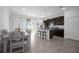 Open-concept kitchen with dark cabinets, granite counters, and dining area with tile floors at 3352 Sw 127Th Lane Rd, Ocala, FL 34473