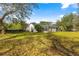 Large backyard with an enclosed patio surrounded by lush greenery and a dark wooden fence at 3621 Sw 52Nd Ter, Ocala, FL 34474