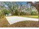 Wide shot of a driveway leading to garages and surrounding landscape with mature trees and foliage at 3621 Sw 52Nd Ter, Ocala, FL 34474