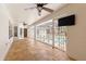 Covered patio area featuring travertine tile, ceiling fans, and view of the screened-in pool at 3621 Sw 52Nd Ter, Ocala, FL 34474