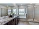 Well-lit primary bath with double vanities, granite countertop, a tub, and glass-enclosed shower at 4236 Sw 53Rd Lane Rd, Ocala, FL 34474