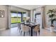 Bright dining area with a modern table setting, stylish curtains, and a sliding glass door with scenic backyard view at 4250 Sw 53Rd Lane Rd, Ocala, FL 34474