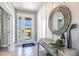 Inviting foyer showcasing a decorative mirror, console table, and light tile flooring for a bright entrance at 4250 Sw 53Rd Lane Rd, Ocala, FL 34474