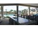 Outdoor kitchen with bar seating beside a community pool surrounded by lounge chairs and tropical landscaping at 4250 Sw 53Rd Lane Rd, Ocala, FL 34474