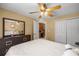 Bedroom featuring a ceiling fan, view to office, large mirror, and white comforter at 4320 Sw 112Th St, Ocala, FL 34476