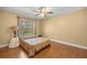 Cozy bedroom featuring hardwood floors, a ceiling fan, and a large window at 4320 Sw 112Th St, Ocala, FL 34476