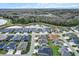 Aerial view showcases this home within a community, with a nearby pond and lush green surroundings at 4384 Pezzullo Cir, The Villages, FL 32163