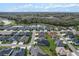 Community aerial showcases homes surrounding a pond amidst lush landscapes and manicured lawns at 4384 Pezzullo Cir, The Villages, FL 32163