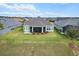 Aerial view of home featuring a well-manicured lawn, lush landscaping, and an outdoor living area at 4384 Pezzullo Cir, The Villages, FL 32163