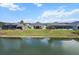 Waterfront backyard features lush green grass and a screened in porch perfect for enjoying the outdoors at 4384 Pezzullo Cir, The Villages, FL 32163