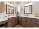Bathroom with dual sinks, granite countertops, dark wood cabinetry, decorative mirrors, and a chandelier at 4384 Pezzullo Cir, The Villages, FL 32163