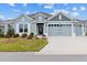 Charming one-story home with a well-manicured lawn and beautiful blue and gray color palette at 4384 Pezzullo Cir, The Villages, FL 32163