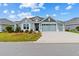 Charming one-story home with a well-manicured lawn and beautiful blue and gray color palette at 4384 Pezzullo Cir, The Villages, FL 32163
