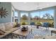 Enclosed lanai features seating, a ceiling fan, and peaceful lake views through large glass windows at 4384 Pezzullo Cir, The Villages, FL 32163