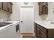 Functional laundry room with washer, dryer, cabinets, sink, countertop, and door at 4384 Pezzullo Cir, The Villages, FL 32163