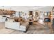 Cozy open-concept room with a fireplace, a large tan couch and decoratively appointed kitchen and hallway at 4384 Pezzullo Cir, The Villages, FL 32163
