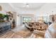 Bright living room with a tan leather couch, a decorative rug, and glass doors leading to the backyard at 4384 Pezzullo Cir, The Villages, FL 32163