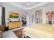 Brightly lit main bedroom with a cozy seating area, tray ceiling, dresser and view to the ensuite bath at 4384 Pezzullo Cir, The Villages, FL 32163