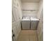 Convenient laundry room featuring a washer, dryer, tiled floor, and shelving for added storage space at 4954 Sw 40Th Pl, Ocala, FL 34474
