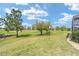 Serene backyard view showcasing a lush lawn and distant golf course at 5111 Nw 35Th Pl, Ocala, FL 34482