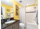 Bright bathroom with yellow walls, a black granite sink, and a shower/tub combination at 5111 Nw 35Th Pl, Ocala, FL 34482