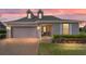 Charming single-story home featuring a two-car garage, brick-paved driveway, and manicured landscaping at sunset at 5111 Nw 35Th Pl, Ocala, FL 34482