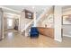 Inviting foyer with staircase and built-in bar area, featuring wood-look tile flooring and neutral color palette at 5111 Nw 35Th Pl, Ocala, FL 34482