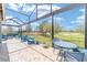This screened-in patio boasts ample seating and a stunning view of the lush green golf course at 5111 Nw 35Th Pl, Ocala, FL 34482