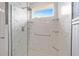 Shower featuring marble-like tile, rain shower head, and a window providing natural light at 5111 Nw 35Th Pl, Ocala, FL 34482