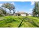 Expansive backyard featuring lush lawn, screened-in patio, and mature shade trees at 530 Nw 113Th Cir, Ocala, FL 34482