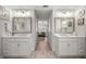 Bathroom with double vanities, framed mirrors, and wood-look tile at 530 Nw 113Th Cir, Ocala, FL 34482