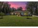 Charming home exterior with a manicured lawn, warm lighting, and a serene twilight sky at 530 Nw 113Th Cir, Ocala, FL 34482