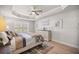 Inviting bedroom with tray ceiling, ceiling fan, shuttered windows, and decorative elements at 530 Nw 113Th Cir, Ocala, FL 34482