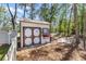 White shed with brown trim and a flower box is situated on a leafy property at 530 Nw 113Th Cir, Ocala, FL 34482