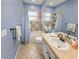 Bright bathroom features a bath and shower combination with blue accents at 5725 Ne 31St Ter, Ocala, FL 34479