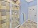Shower featuring neutral tile, a glass door, and modern fixtures at 5725 Ne 31St Ter, Ocala, FL 34479