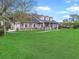 Quaint home with a lush lawn, mature trees, and inviting front porch with rocking chairs at 5725 Ne 31St Ter, Ocala, FL 34479