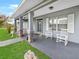 Inviting front porch features classic columns, rocking chairs and attractive front door with decorative glass at 5725 Ne 31St Ter, Ocala, FL 34479