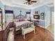 Spacious main bedroom featuring hardwood floors, tray ceilings, and an elegant wrought iron bed frame at 5725 Ne 31St Ter, Ocala, FL 34479