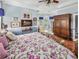 This main bedroom features a floral bedspread and views of the backyard and access to the outdoors at 5725 Ne 31St Ter, Ocala, FL 34479