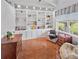 Bright office space with custom built-in shelving, hardwood floors, and a large window overlooking the exterior at 5725 Ne 31St Ter, Ocala, FL 34479