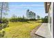 Serene backyard with a lush lawn, young trees, and a view from the back patio at 5870 Sw 93Rd Cir, Ocala, FL 34481