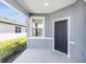 Covered front porch with a gray front door and decorative security grate at 5870 Sw 93Rd Cir, Ocala, FL 34481