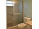 Tiled shower room with glass doors, a toilet, and a marble countertop at 6548 Sw 84Th Place Rd, Ocala, FL 34476