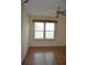 Bedroom features natural light from a window with blinds, complemented by wood flooring and a ceiling fan at 6548 Sw 84Th Place Rd, Ocala, FL 34476