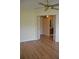 A bedroom with wood flooring and a ceiling fan, with an open doorway leading to a bathroom at 6548 Sw 84Th Place Rd, Ocala, FL 34476