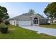 Exterior of a one-story home with a well-maintained lawn, two-car garage, and screened entryway at 6548 Sw 84Th Place Rd, Ocala, FL 34476