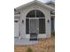 Front porch view with a screened enclosure, decorative stone accents, and a neutral color scheme at 6548 Sw 84Th Place Rd, Ocala, FL 34476