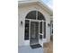 View of the home's screened entry porch with stone detailing, leading to a partially open front door at 6548 Sw 84Th Place Rd, Ocala, FL 34476